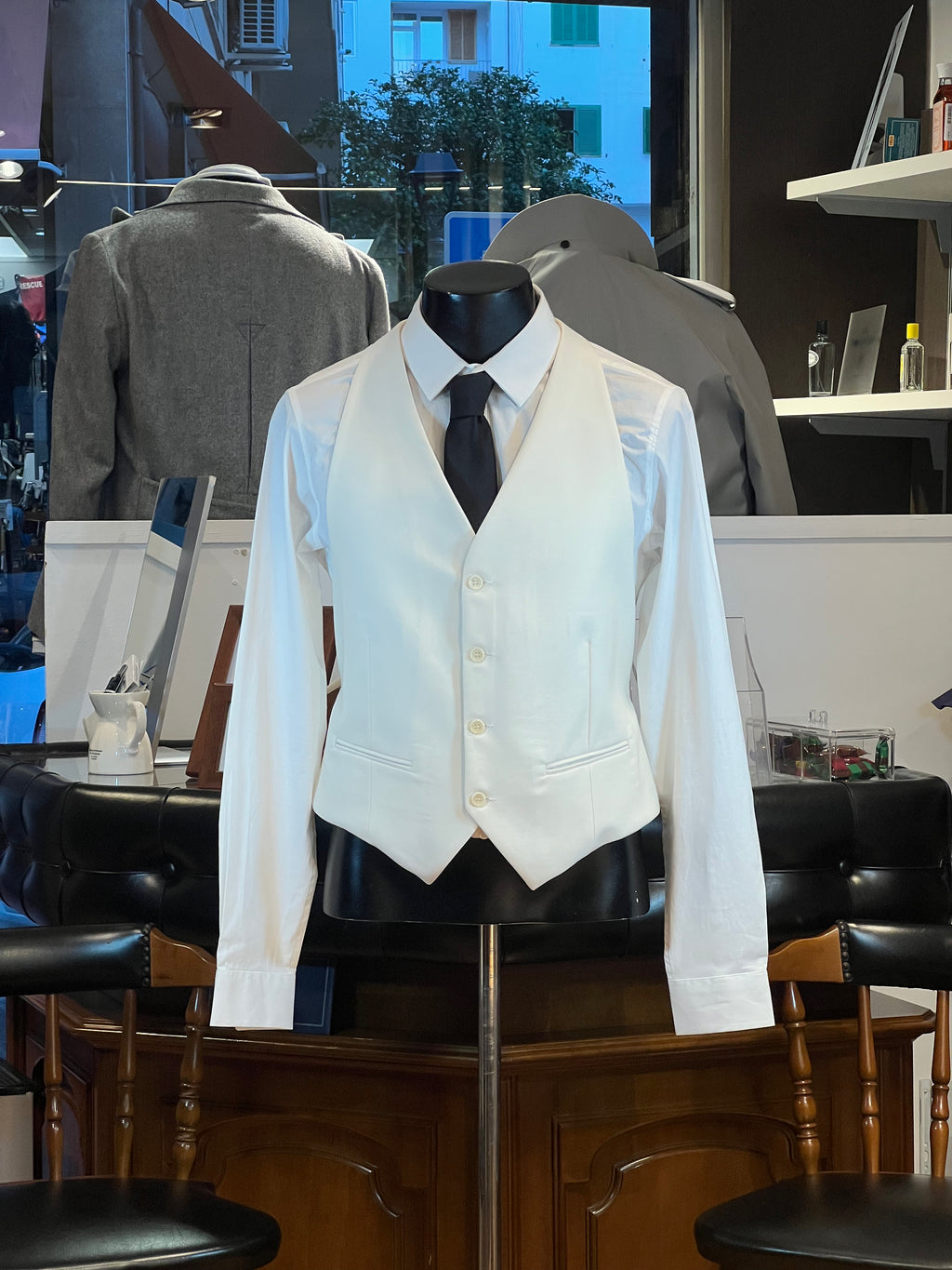 Chaleco de vestir elegante color crema en maniquí con camisa blanca y corbata negra